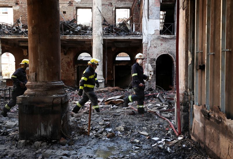 Firemen walk through the burnt out remains of Jagger Library