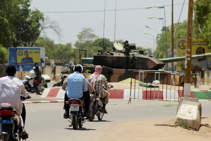 FILE PHOTO: People drive past a Chad army tank near