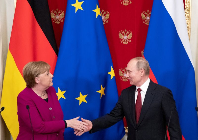 FILE PHOTO: Russian President Putin and German Chancellor Merkel hold