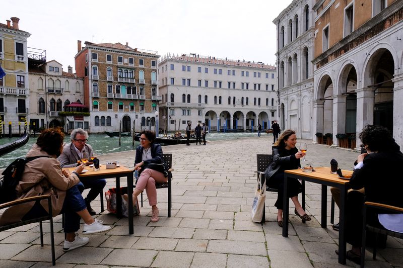 Italians sit at a bar as much of the country