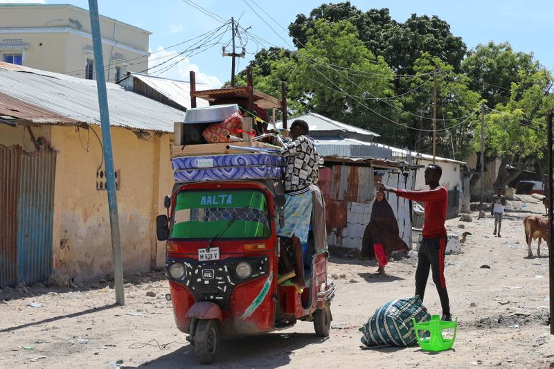 Residents load their belongings into rickshaws as they flee, in