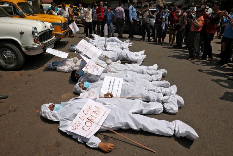 FILE PHOTO: Demonstrators in protective suits and masks lie on