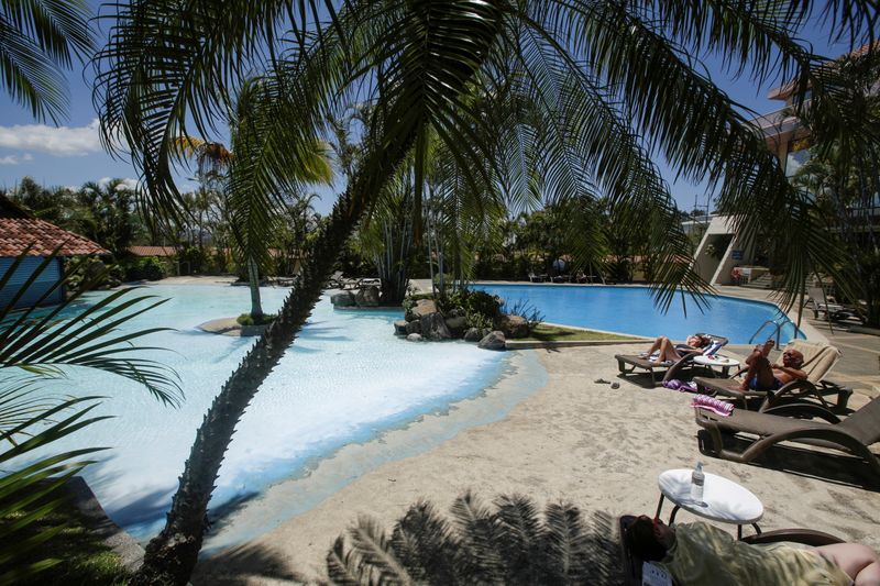 FILE PHOTO: Tourists sunbathe near a pool in a hotel,