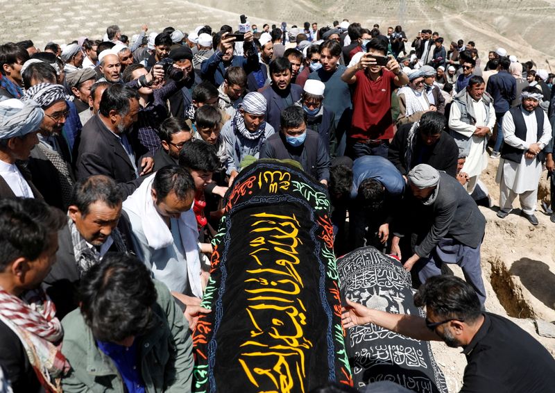 FILE PHOTO: Afghan men prepare victims’ coffins for mass funeral