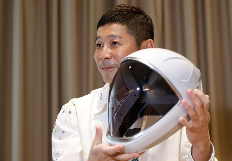 Japanese billionaire Yusaku Maezawa poses with a space suit helmet