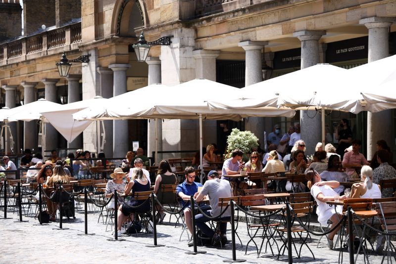 People sit in an outdoor dining area in Covent Garden,