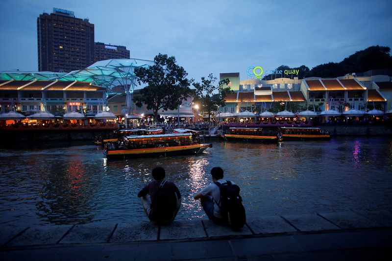 FILE PHOTO: People sit on the banks of the Singapore