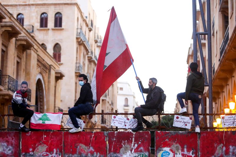 FILE PHOTO: A demonstrator holds a Lebanese flag during a