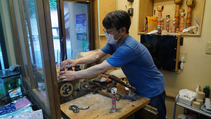 Sixth generation kokeshi maker Kunitoshi Abe cleans up after making