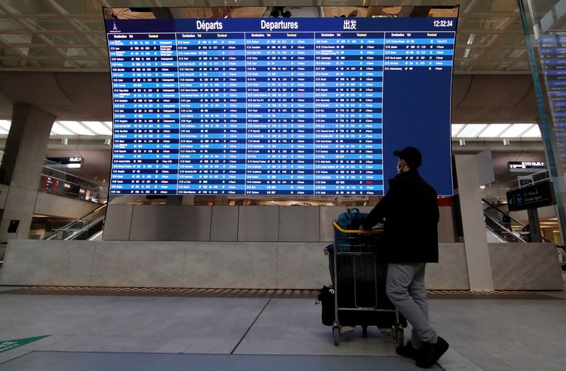 A passenger looks at a departures board with cancelled flights