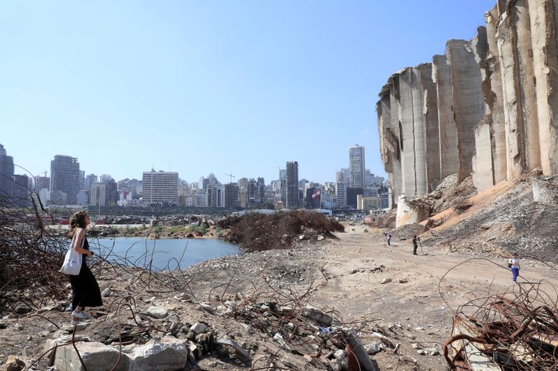 FILE PHOTO: A woman walks on rubble at the site