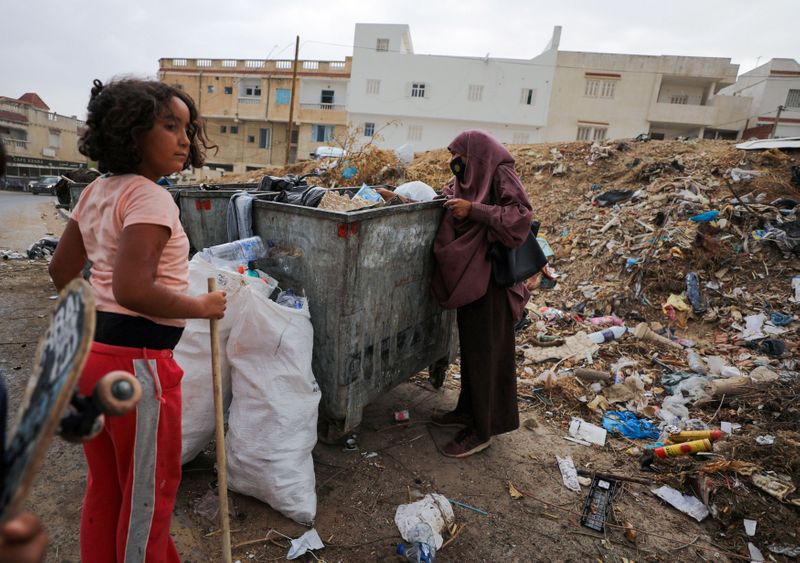 Tunisian mother, Jamila Ghuwili, 55, looks for plastic in a