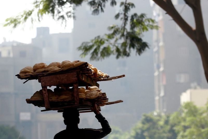 FILE PHOTO: A bakery worker carries fresh bread in Cairo