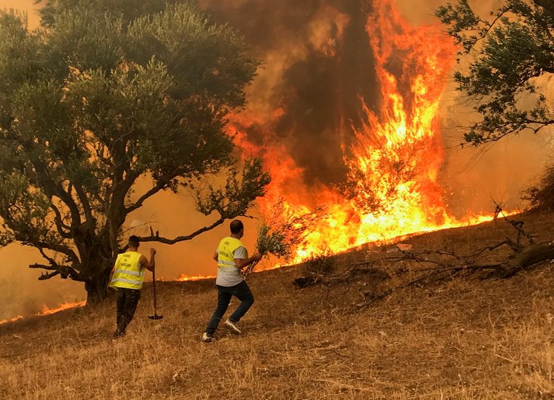 Men attempt to put out a fire in Iboudraren village