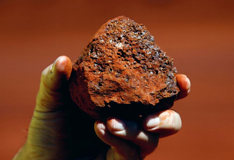 FILE PHOTO: A miner holds a lump of iron ore