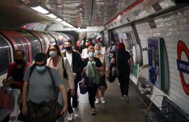 People walk along a platform at Oxford Circus underground station,