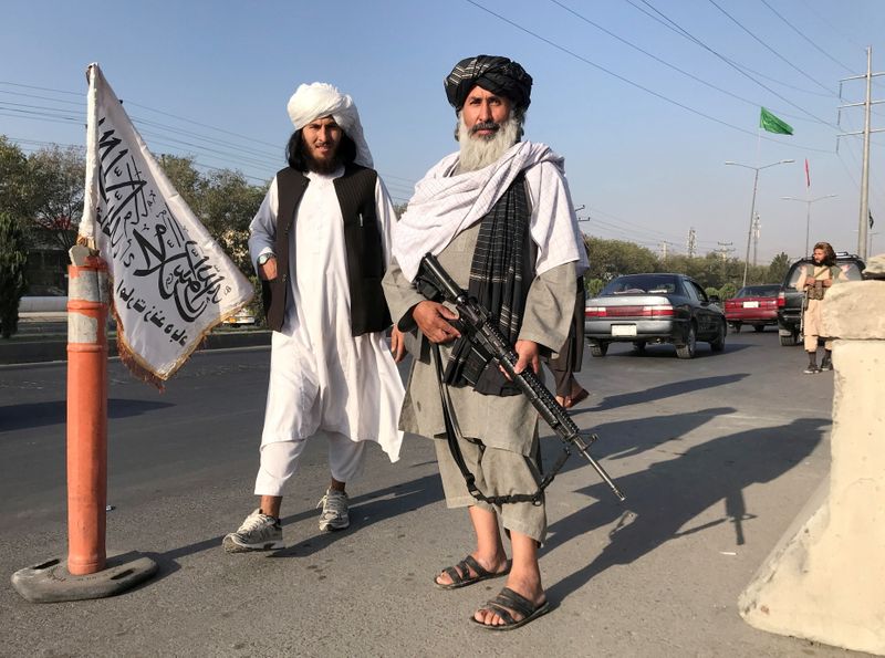 FILE PHOTO: Taliban fighter stand outside the Interior Ministry in