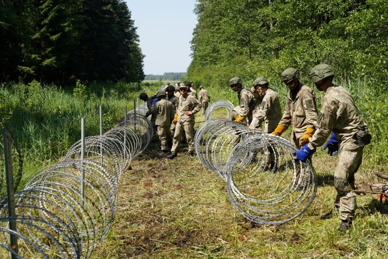 FILE PHOTO: Lithuanian army soldiers install razor wire along the