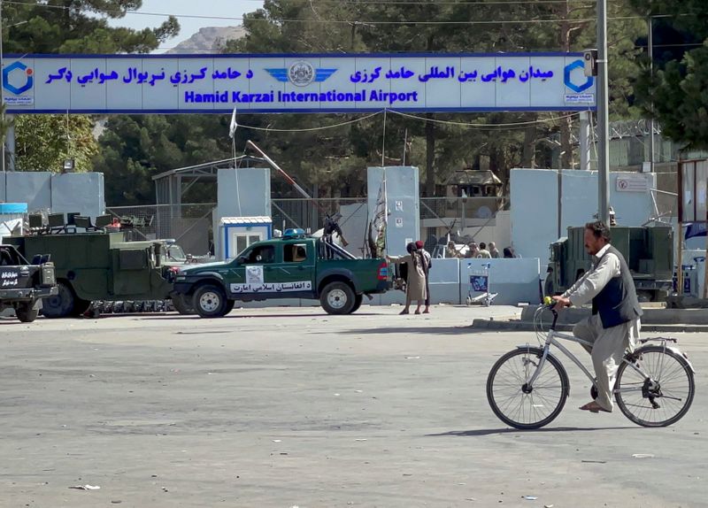 Taliban stand at the entrance gate of Hamid Karzai International