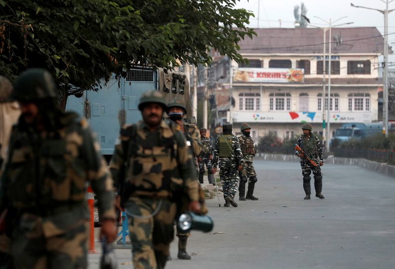 Indian security force personnel patrol near the residence of Syed