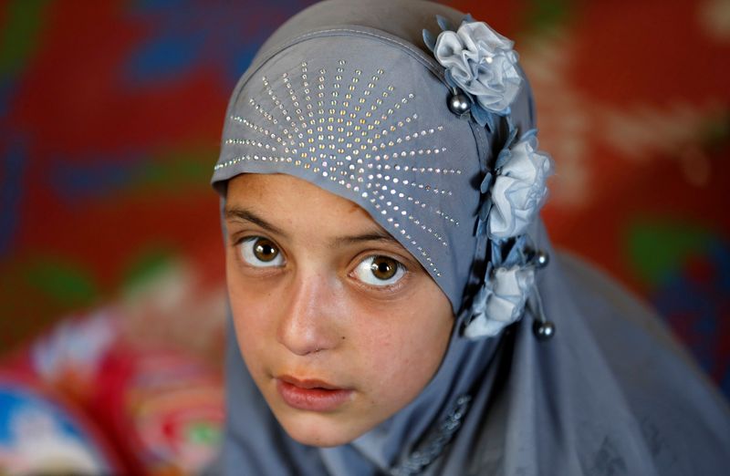 An internally displaced Afghan girl looks on as she attends