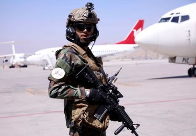 Member of Taliban forces stands guard at Hamid Karzai International