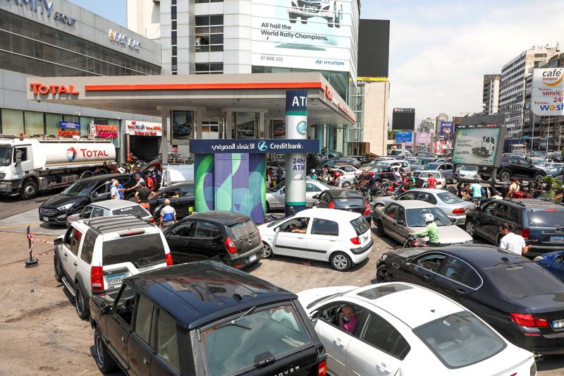 FILE PHOTO: People wait in cars to get fuel at