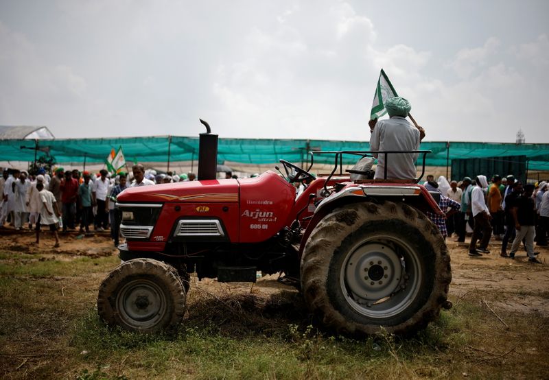 FILE PHOTO: A farmer sits on a tractor as he