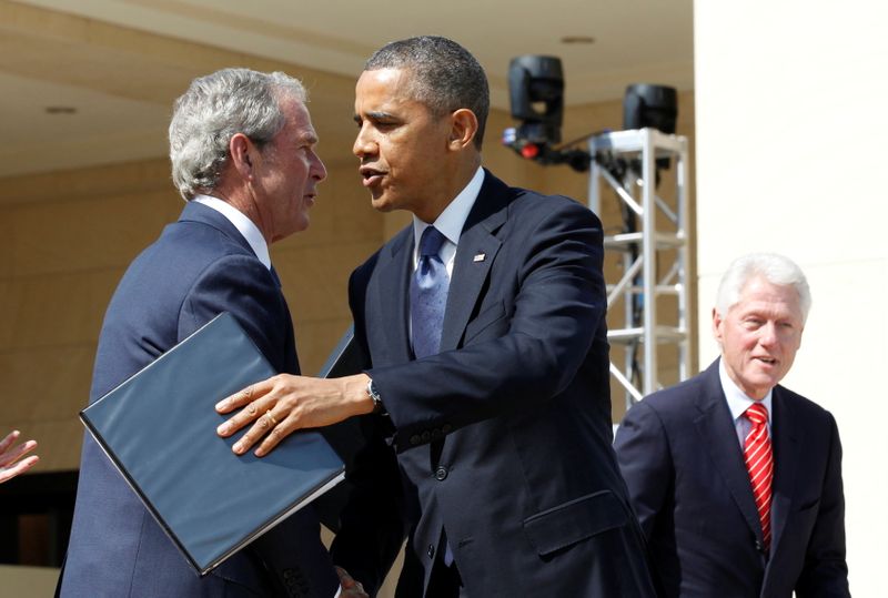 FILE PHOTO: U.S. President Barack Obama embraces George W. Bush