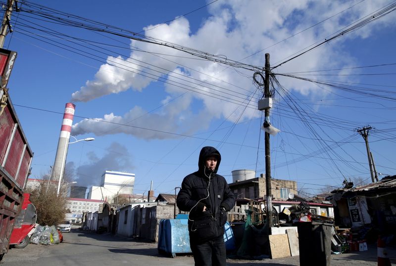 FILE PHOTO: FILE PHOTO: A man walks near a coal-fired