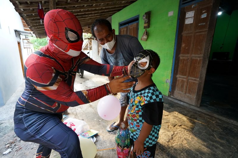 Man donning superhero costume brings cheer to children confined to
