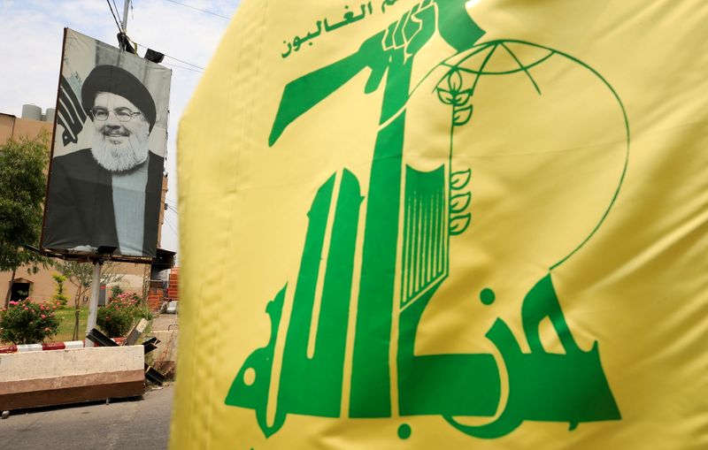 FILE PHOTO: A Hezbollah flag and a poster depicting Lebanon’s