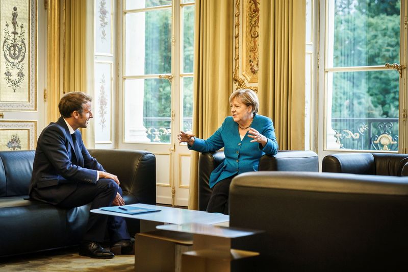 French President Emmanuel Macron talks to German Chancellor Angela Merkel