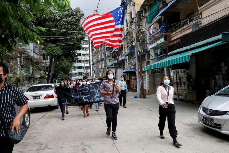 FILE PHOTO: People march with the federal flag as they