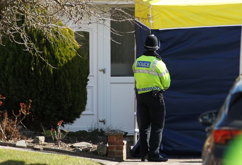 A police officer stands guard outside of the home of