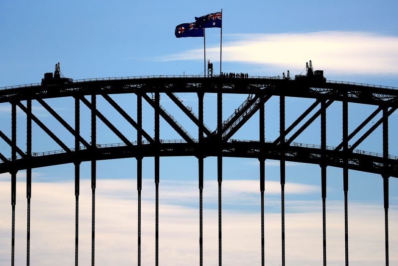 Tourists stand atop of the Sydney Harbour Bridge next to