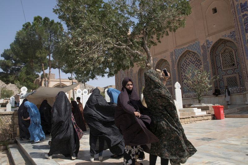 Afghan women walk at a mosque in Herat