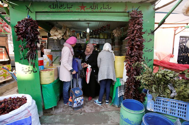 FILE PHOTO: People shop at a Tadamun market in the