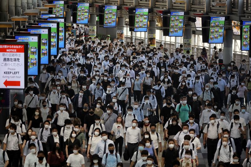 Commuters wearing face masks arrive at Shinagawa Station