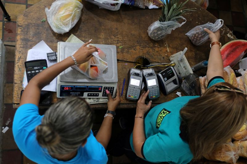 FILE PHOTO: Paying with U.S. dollars in Caracas