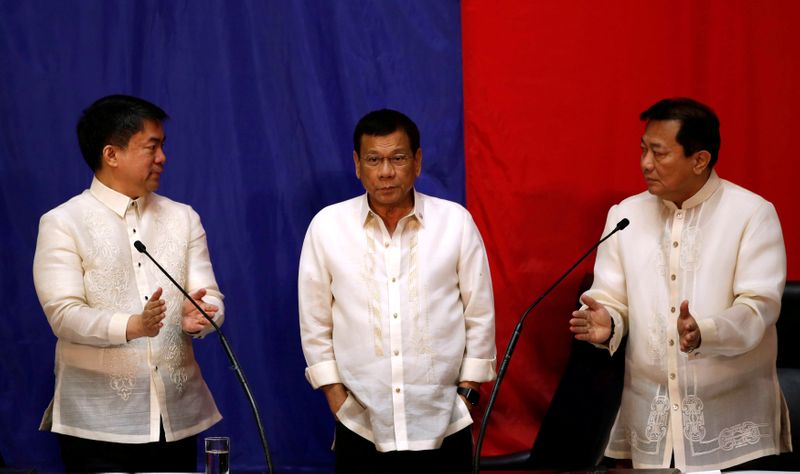 Philippine President Rodrigo Duterte stands in between Senate President Aquilino