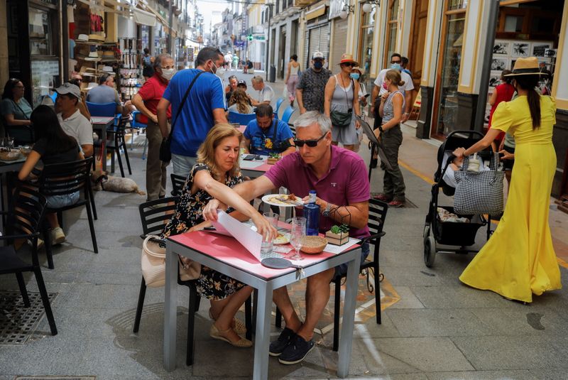Tourists sit at the terrace of a bar amid the