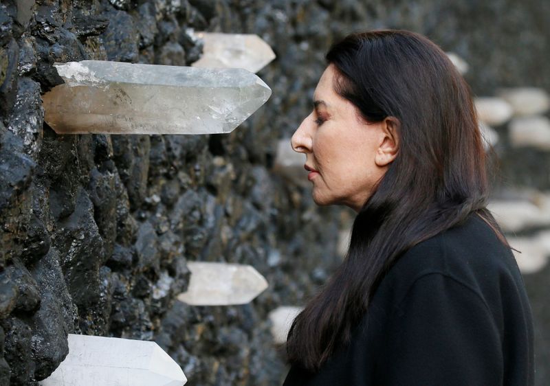 Artist Marina Abramovic performs next to her artwork “Crystal Wall