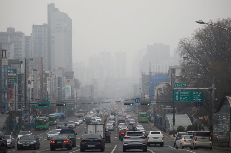 Vehicles move on a road on a polluted day in