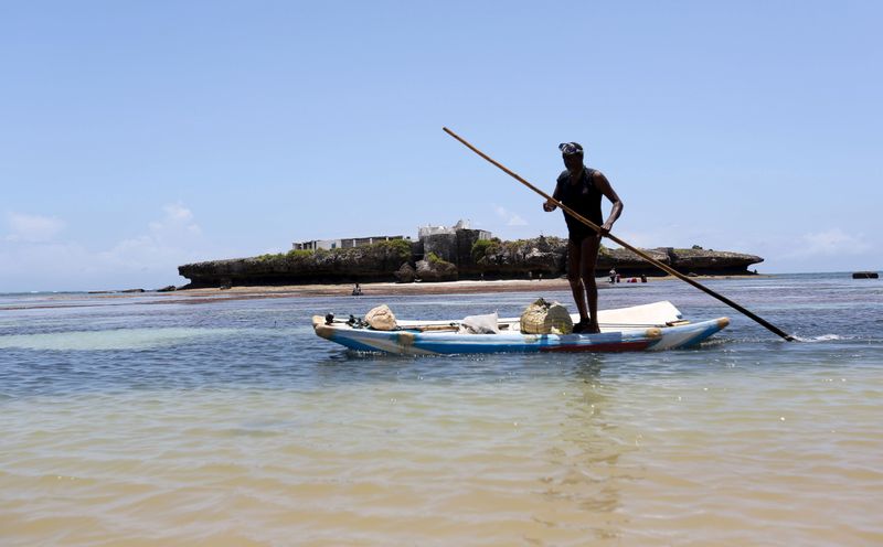 FILE PHOTO: A fisherman paddles his boat in the Indian