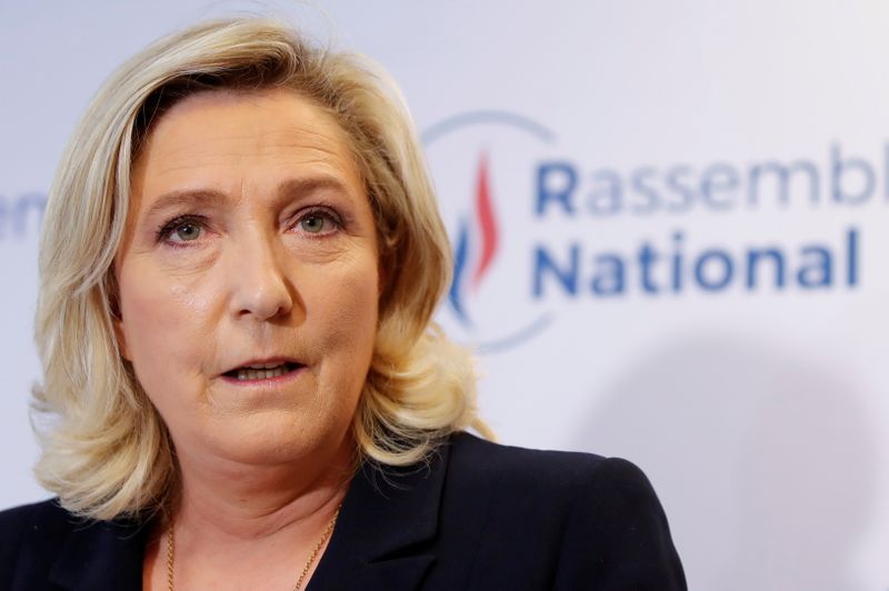 FILE PHOTO: French far right leader Marine Le Pen reacts