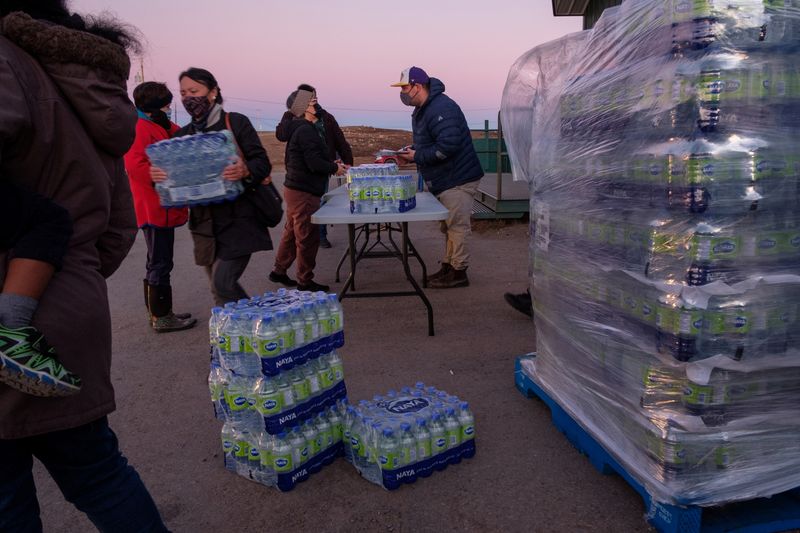 Residents line up to collect bottled water after fuel contamination