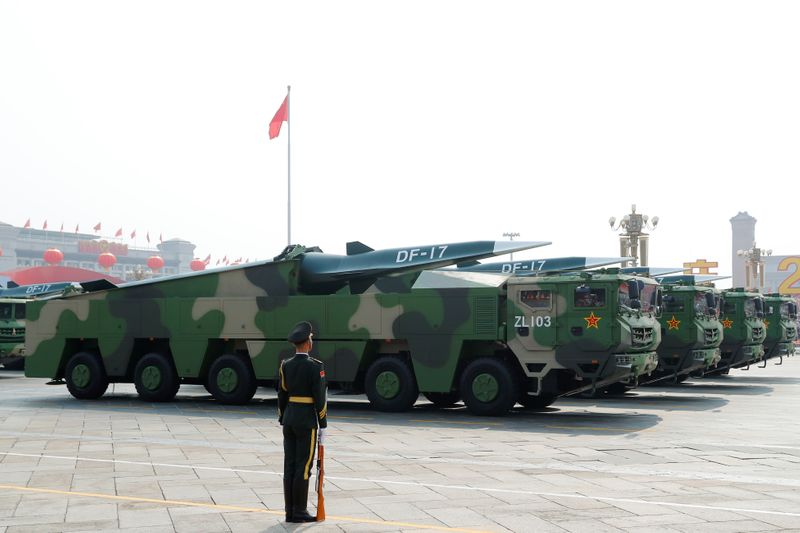 FILE PHOTO: Military vehicles carrying hypersonic missiles DF-17 drive past