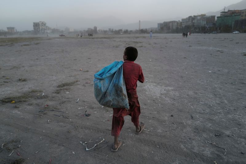 Eftekhar, 14, carries a bag filled with plastic bottles he