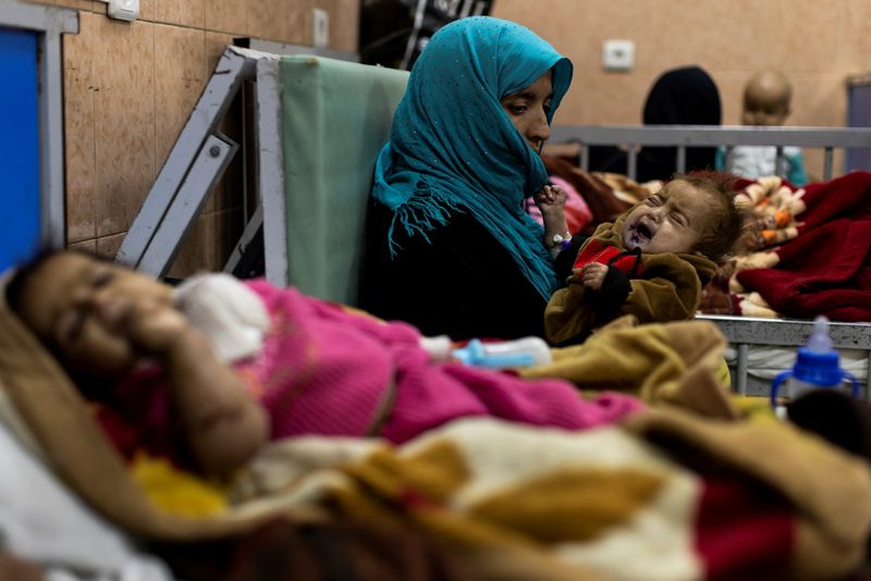 A mother holds her baby at the malnutrition ward of